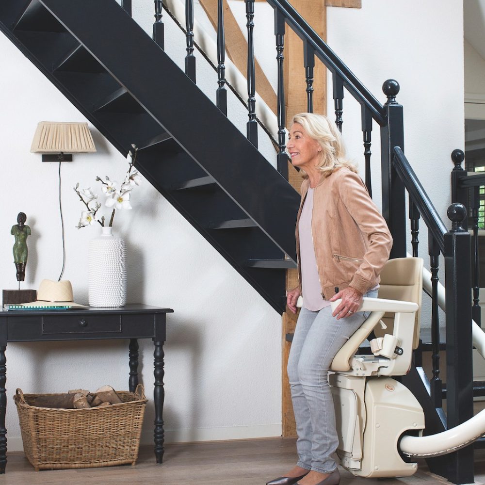 which-stairlift-guide -stairlift reviews-and advice - woman-getting-of-a-stairlift-at-the-bottom-of-the-stairs
